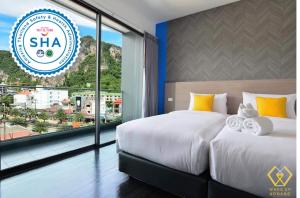 pokój hotelowy z dwoma łóżkami i oknem w obiekcie Wake Up Aonang Hotel w Aonang Beach