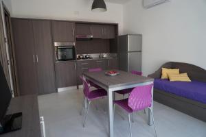 a kitchen with a table and purple chairs in a room at Tenuta Santa Maria in Mattinata