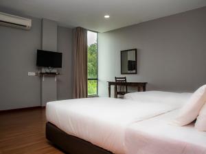 a hotel room with two beds and a television at OYO 90059 Ltk Home in Kanowit