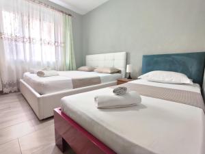 Habitación de hotel con 2 camas y sofá en Tirana City Center Apartment, en Tirana