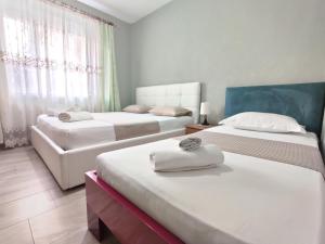 a hotel room with two beds and a couch at Tirana City Center Apartment in Tirana +57 photos