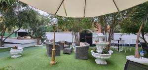 eine Terrasse mit Stühlen, einem Sonnenschirm und Bäumen in der Unterkunft Escala Suites in Madrid