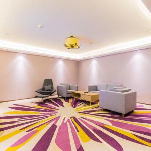 a living room with couches and a colorful rug at Lavande Hotel (Gaozhou Xiantai Bridge Branch) in Maoming