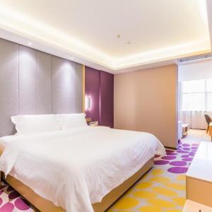 a bedroom with a large white bed in a room at Lavande Hotel (Gaozhou Xiantai Bridge Branch) in Maoming