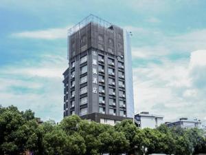 a tall gray building with trees in front of it at Lavande Hotel Nanchang Bayi Square Branch in Nanchang