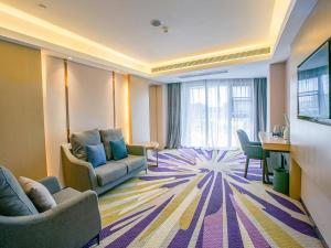 ein Hotelzimmer mit 2 Sofas und einem Schreibtisch in der Unterkunft Lavande Hotel (Nanchang Qianhu Avenue Nanchang Univercity Branch) in Nanchang