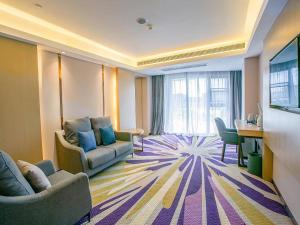 a hotel room with two couches and a desk at Lavande Hotel (Nanchang Qianhu Avenue Nanchang Univercity Branch) in Nanchang