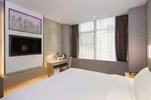a bedroom with a large bed and a tv at Lavande Hotel Changsha Pedestrian Street Nanmenkou Metro Station Branch in Changsha