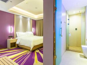 a hotel room with a bed and a bathroom at Lavande Hotel Qiqihar Supervisory Office in Qiqihar