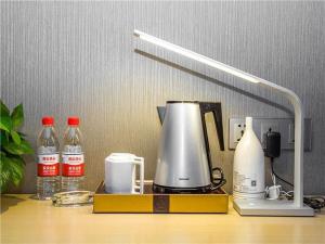 een koffiezetapparaat en flessen water op een tafel bij Lavande Hotel (Ganzhou Golden Plaza Branch) in Ganzhou