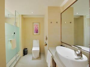 a bathroom with a sink and a toilet and a mirror at Lavande Hotel (Siping Wanda Plaza Branch) in Siping +32 photos