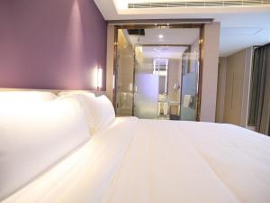 XianyangにあるLavande Hotel Xianyang Yuquan Road Wanda Plaza Branchのシャワー付きの客室で、白い大型ベッド1台が備わります。