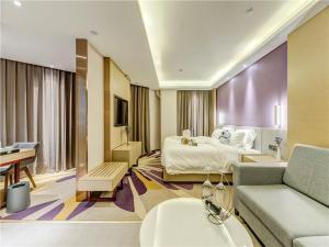 唐山市にあるLavande Hotel Tangshan Convention and Exhibition Yuanyang Cityのベッドとソファ付きのホテルルーム