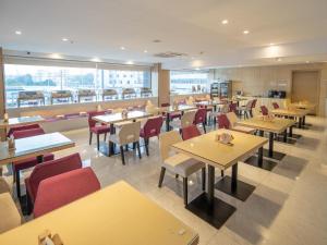 a restaurant with tables and chairs and a cafeteria at Lavande Hotel Zhongshan Nanlang Light Rail Station in Zhongshan