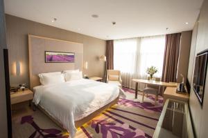 a hotel room with a large bed and a table at Lavande Hotel Xuzhou East High-speed Rail Station Jinshanqiao Development Zone Branch in Xuzhou