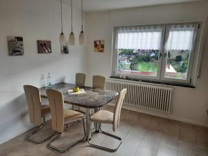 a dining room with a table and chairs and a window at Haus am Schroffen in Ottenhöfen