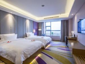 una camera d'albergo con due letti e una televisione di Lavande Hotel (Nanchang Qingshan Lake High-tech Branch) a Nanchang
