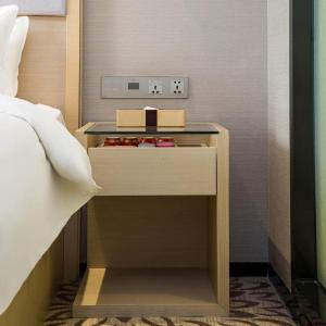 a bed room with a night stand next to a bed at Lavande Hotel Changsha High-speed Railway Station Shuling in Changsha