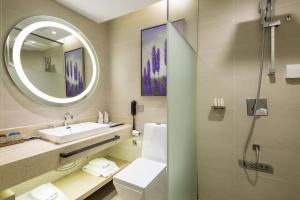 a bathroom with a sink and a toilet and a mirror at Lavande Hotel Changsha High-speed Railway Station Shuling in Changsha