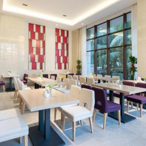 a dining room with tables and purple chairs at Lavande Hotel Haikou Binhai Avenue in Haikou