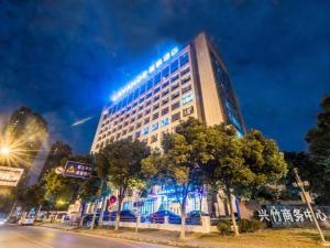 a building with a lit up sign on top of it at Lavande Hotel Wuxi Taihu Avenue in Wuxi