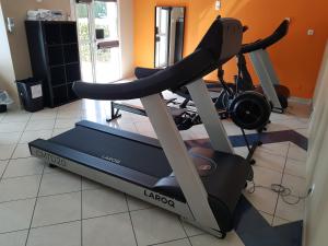 a room with a gym with a treadmill at Hôtel Ariane in Istres