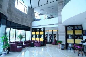a lobby of a building with purple furniture and windows at Lavande Hotel Nanchang West Railway Station Xinjian Branch in Nanchang