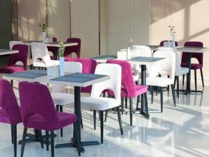 um grupo de mesas e cadeiras com cadeiras roxas em Lavande Hotel Suqian Yanghe New District em Suqian