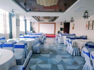 a banquet hall with white tables and blue chairs at Lavande Hotel (Yangzhou Jiangwangshui Street RT-Mart Branch) in Yangzhou