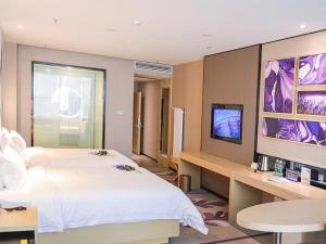 a bedroom with a large white bed and a television at Lavande Hotel Xuzhou New Town Midea Plaza in Xuzhou