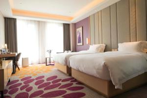 a hotel room with two beds and a desk at Lavande Hotel (Shijiazhuang Luquan Baoduzhai Beiguo Shopping Center Branch) in Shijiazhuang +37 photos