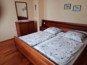 1 dormitorio con 1 cama con cabecero de madera en Haus am Schroffen en Ottenhöfen