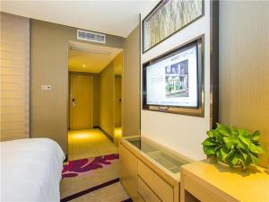 Lavande Hotel (Ganzhou Golden Plaza Branch) في غانتشو: غرفة نوم بسرير وتلفزيون بشاشة مسطحة