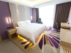 um quarto com uma cama grande e uma janela grande em Lavande Hotel Suqian Yanghe New District em Suqian