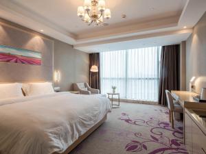 ein Hotelzimmer mit einem Bett und einem großen Fenster in der Unterkunft Lavande Hotel (Ganzhou Railway Station Branch) in Ganzhou
