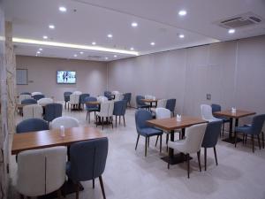 JilinにあるLavande Hotel Jilin Songjiang Road Jiangwan Bridge Branchのテーブルと椅子が備わる広い客室です。