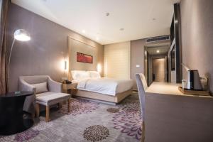 une chambre d'hôtel avec un lit et une chaise dans l'établissement Lavande Hotel (Liupanshui Ancient Town Branch), à Shuicheng