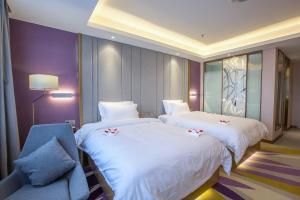 a hotel room with two beds and a chair at Lavande Hotel (Fuzhou Wanda Branch) in Fuzhou