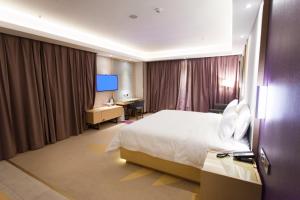 a hotel room with a bed and a desk at Lavande Hotel Rizhao Xinshi District Branch in Rizhao
