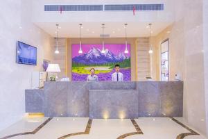un vestíbulo con una gran pintura en la pared en Lavande Hotel Xinyang Municipal Government Branch, en Xinyang