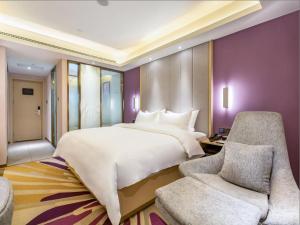 Lavande Hotel Langfang City Government في Langfang: غرفة نوم بسرير ابيض كبير وكرسيين
