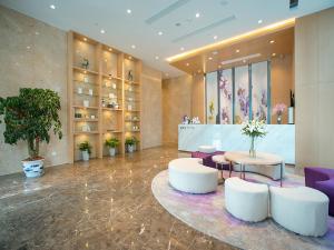 eine Lobby mit zwei weißen Stühlen und einem Tisch in der Unterkunft Lavande Hotel (Nanchang Qianhu Avenue Nanchang Univercity Branch) in Nanchang