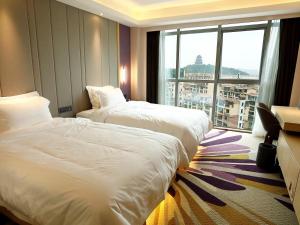 a hotel room with two beds and a large window at Lavande Hotel Jiujiang Jiujiang College in Jiujiang