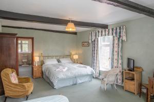 um quarto com uma cama, uma televisão e uma janela em New House Farm Bed and Breakfast em Longhope