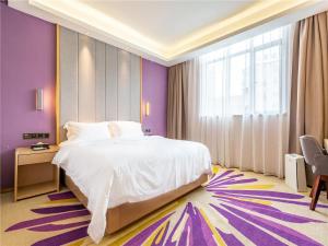 um quarto com uma grande cama branca e paredes roxas em Lavande Hotel(Nanchang Qingshan Road Subway Station Branch) em Nanchang
