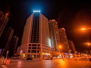 un edificio alto con luces encima por la noche en Lavande Hotel Zhangjiakou Victoria Plaza, en Zhangjiakou