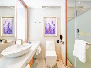 een witte badkamer met een wastafel en een douche bij Lavande Hotel (Shenyang Olympic Center Wanda Branch) in Shenyang