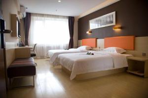 um quarto de hotel com duas camas e uma janela em 7 Days Premium Jiaozuo Renmin Road Teachers College em Jiaozuo