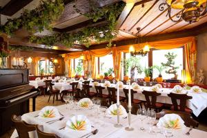 a large dining room with white tables and a piano at Hotel Schiff Nagold in Nagold