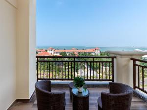 a balcony with chairs and a table with a view at Lavande Hotel Haikou Binhai Avenue in Haikou